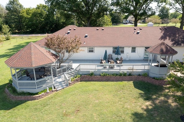 rear view of house with a wooden deck, a lawn, and a gazebo