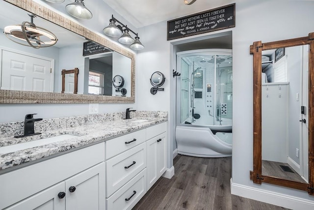 bathroom with vanity, enclosed tub / shower combo, and wood-type flooring