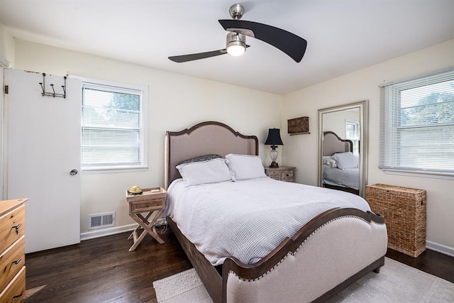 bedroom with ceiling fan, dark hardwood / wood-style flooring, and multiple windows