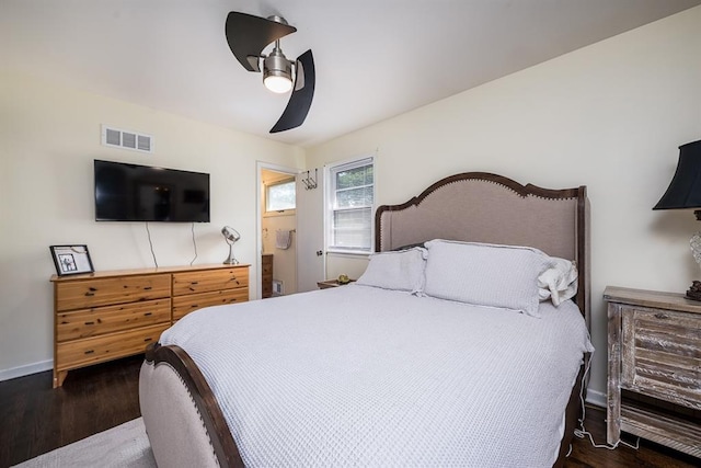 bedroom with ceiling fan, ensuite bathroom, and dark hardwood / wood-style flooring