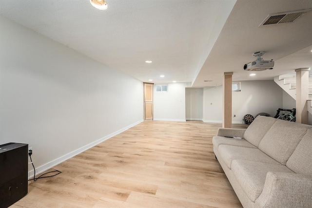 living room with light wood-type flooring and decorative columns