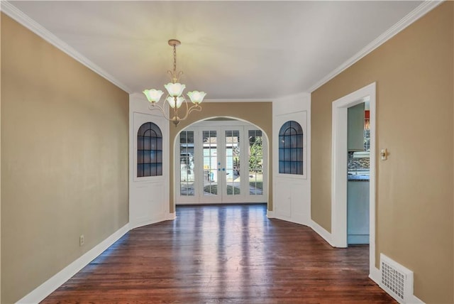 unfurnished dining area featuring french doors, ornamental molding, dark hardwood / wood-style floors, and an inviting chandelier