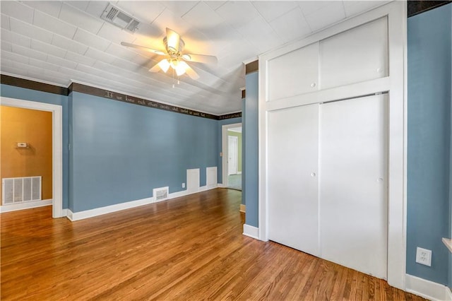 unfurnished bedroom with hardwood / wood-style flooring, ceiling fan, and a closet