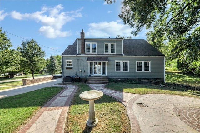 view of front of home featuring french doors, central AC, and a front lawn