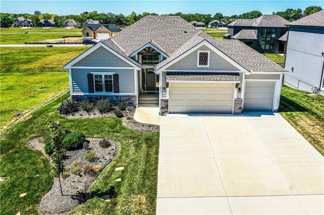 craftsman inspired home featuring a garage and a front lawn