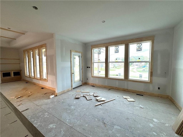 unfurnished living room with baseboards