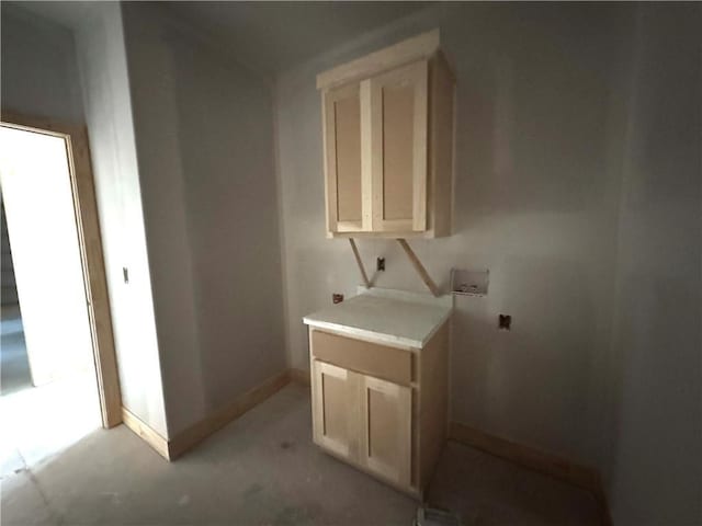 clothes washing area with laundry area and baseboards