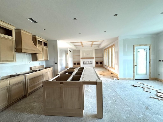 3215 SW Enoch St, Lees Summit, MO 64082 - kitchen with premium range hood, an island with sink, open floor plan, baseboards, and a fireplace