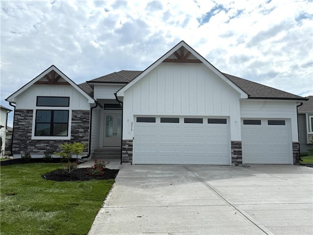 3215 SW Enoch St, Lees Summit, MO 64082 - view of front of home featuring stone siding, a garage, board and batten siding, and concrete driveway