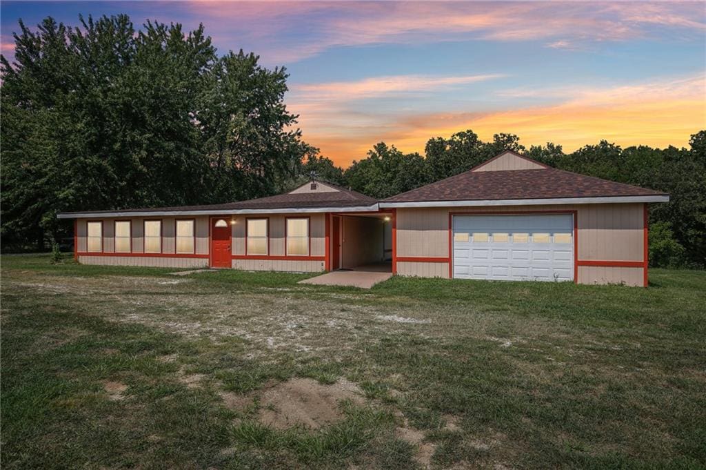 single story home with a lawn and a garage