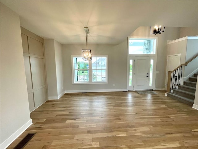 foyer entrance with light hardwood / wood-style flooring and a notable chandelier