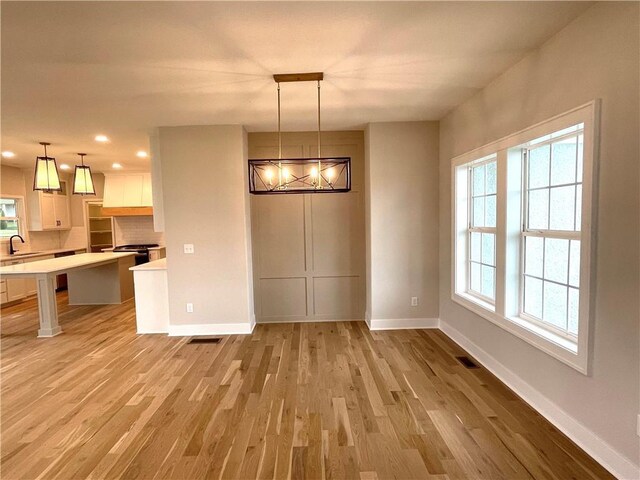 unfurnished dining area with light hardwood / wood-style flooring and sink