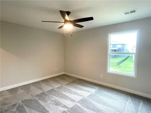 carpeted spare room with a healthy amount of sunlight and ceiling fan