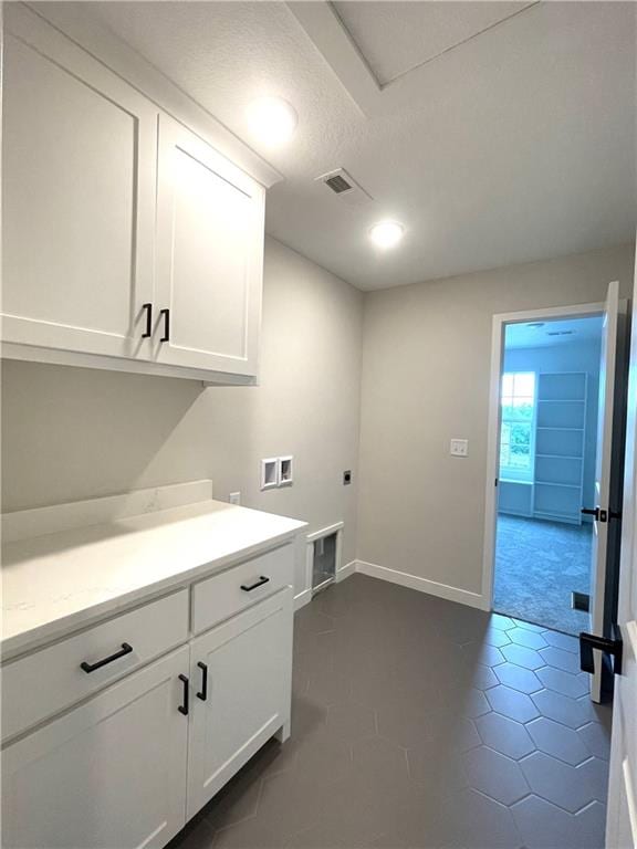 laundry area with washer hookup, hookup for an electric dryer, cabinets, and a textured ceiling