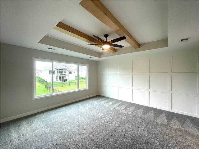 carpeted empty room with ceiling fan and beam ceiling