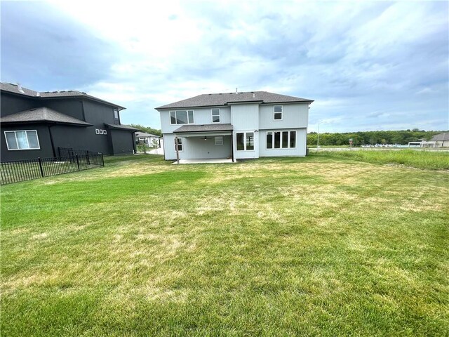 rear view of property featuring a lawn