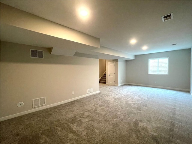 basement with stairs, light colored carpet, and visible vents