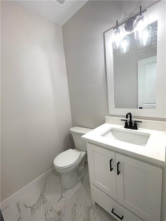 bathroom featuring marble finish floor, toilet, vanity, and baseboards