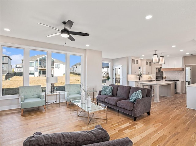 living room featuring recessed lighting, light wood-type flooring, baseboards, and a ceiling fan