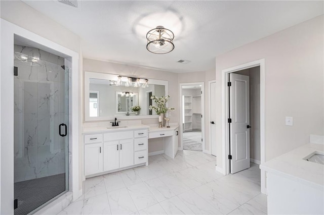 full bath featuring vanity, a marble finish shower, an inviting chandelier, a spacious closet, and marble finish floor