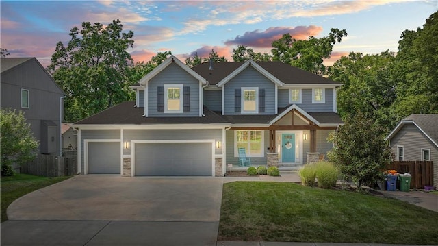 view of front facade with concrete driveway, stone siding, a garage, a yard, and fence