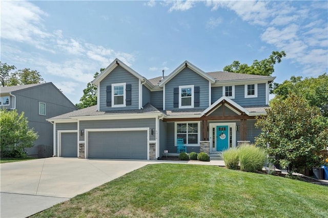 craftsman house with an attached garage, a front lawn, stone siding, and driveway