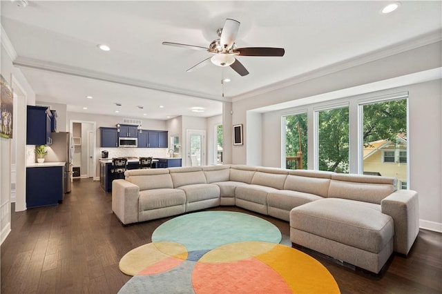 living room featuring dark wood-style flooring, ornamental molding, ceiling fan, and plenty of natural light