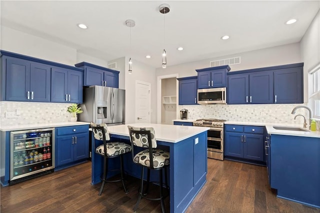 kitchen featuring wine cooler, blue cabinets, a sink, and appliances with stainless steel finishes