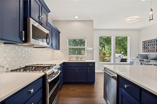 kitchen featuring blue cabinets, light countertops, a sink, and appliances with stainless steel finishes