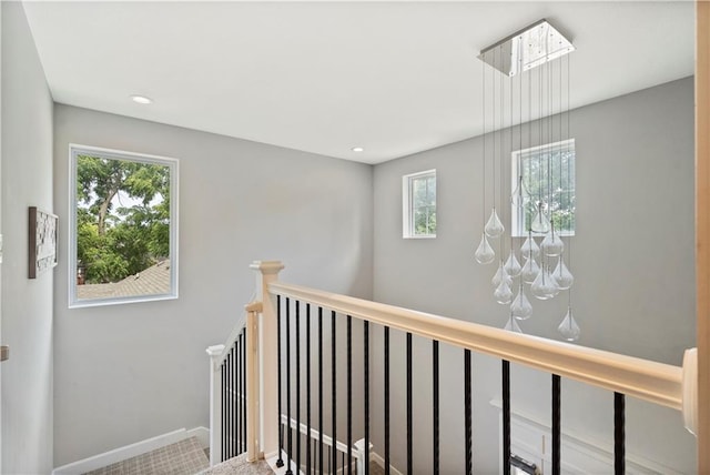 hallway with baseboards, an upstairs landing, and recessed lighting