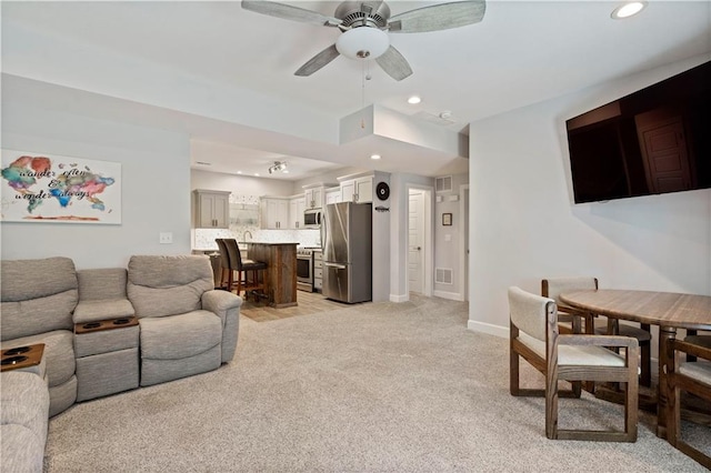 living area featuring visible vents, baseboards, ceiling fan, recessed lighting, and light colored carpet