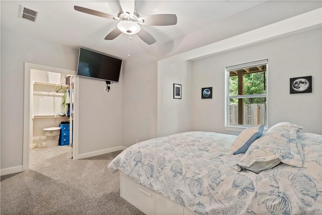 carpeted bedroom featuring visible vents, a closet, baseboards, a spacious closet, and ceiling fan