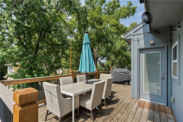 wooden terrace featuring outdoor dining area and grilling area