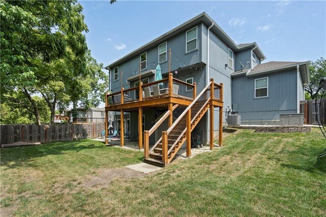 back of house featuring a lawn, stairway, central AC unit, fence, and a deck