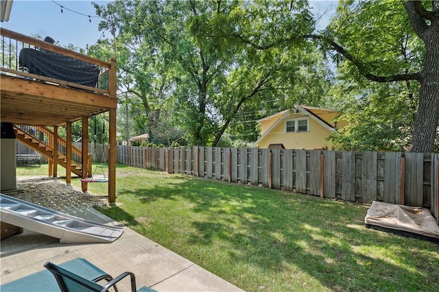 view of yard with a fenced backyard, a wooden deck, and stairs