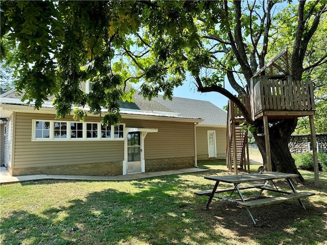 back of house featuring a wooden deck and a yard