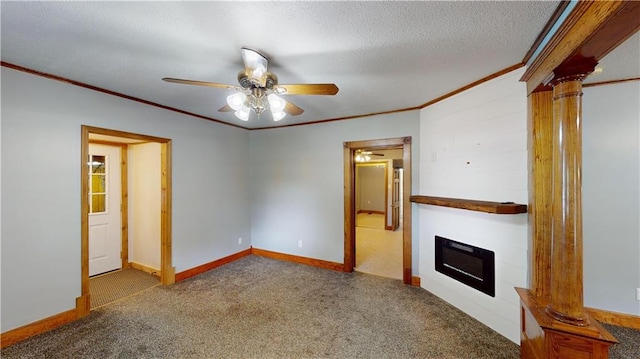 unfurnished living room with a textured ceiling, carpet floors, ornate columns, ornamental molding, and ceiling fan