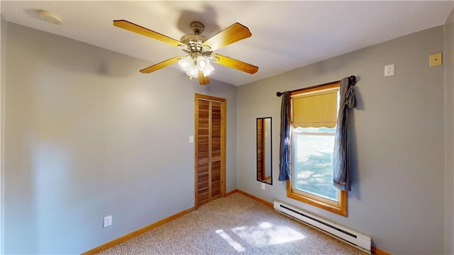 carpeted spare room featuring a baseboard radiator and ceiling fan