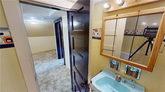 bathroom featuring tile walls and sink