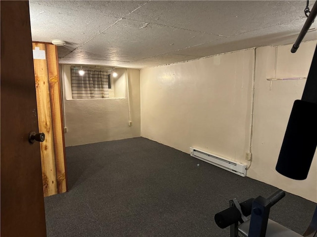 basement featuring a baseboard heating unit and carpet flooring