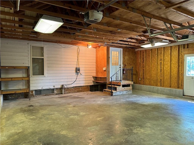 garage featuring a garage door opener and wood walls