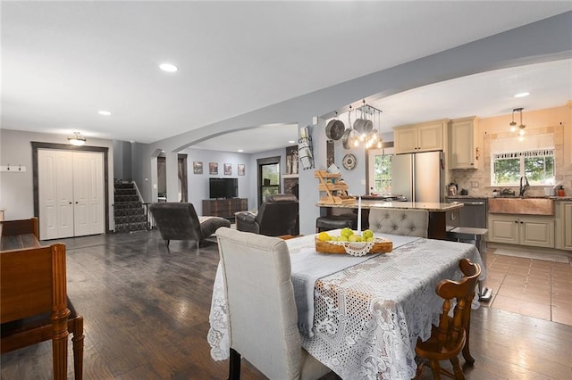 dining room with sink, hardwood / wood-style floors, and decorative columns