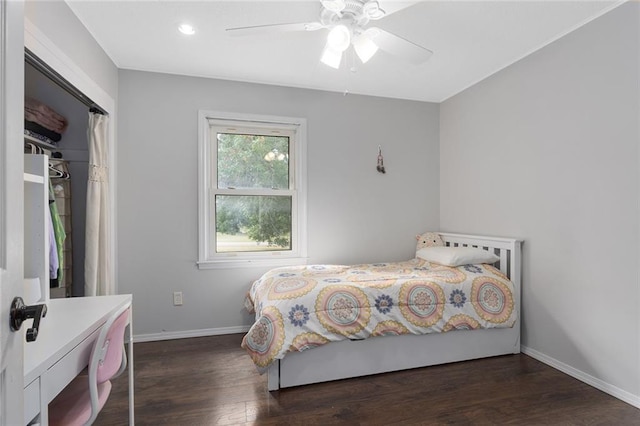 bedroom featuring dark wood-type flooring, a closet, and ceiling fan