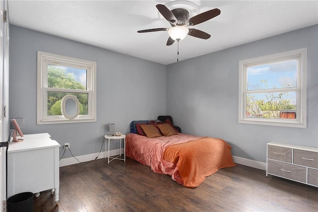 bedroom with dark hardwood / wood-style flooring and ceiling fan