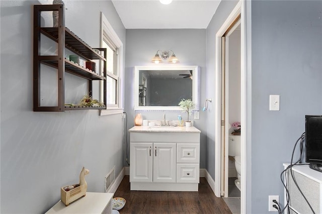 bathroom with vanity, toilet, and hardwood / wood-style floors