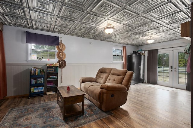 living room with water heater, wood-type flooring, and french doors