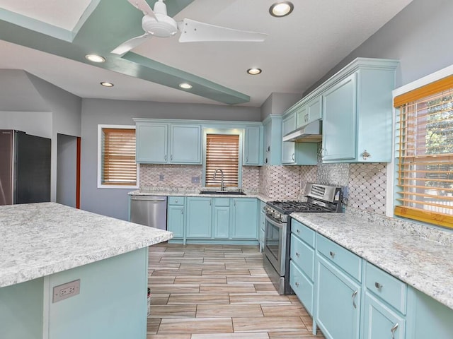 kitchen featuring blue cabinets, sink, appliances with stainless steel finishes, ceiling fan, and backsplash