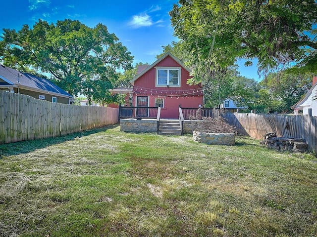 view of yard with a wooden deck and a fenced backyard