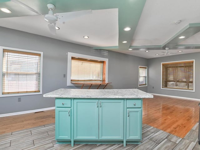 kitchen featuring blue cabinets, a center island, and ceiling fan