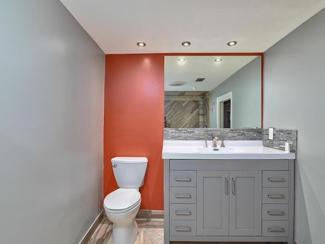 bathroom with hardwood / wood-style flooring, vanity, and toilet